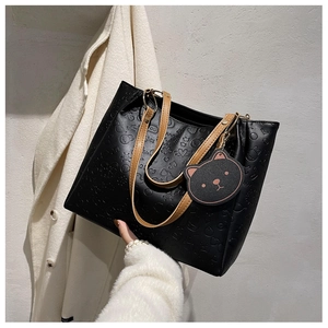 Close-up of black embossed faux leather tote bag with cartoon bear and rabbit patterns