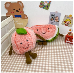 Detail of plush peach and watermelon cartoon crossbody bags with golden chains
