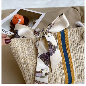 Detail of hand-woven straw tote with striped ribbon and cotton rope handles