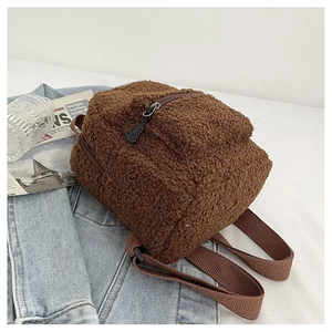 Detailed view of a brown faux shearling mini backpack on casual background