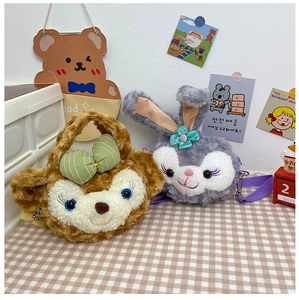 Close-up of cartoon fruit plush crossbody bags with colorful nylon straps on a plaid cloth