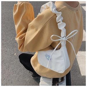 Detailed view of white nylon underarm bag with blue whale patch and bow tie decoration