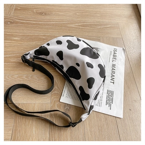 Detail of cow print nylon crescent bag with adjustable strap and smooth zipper closure