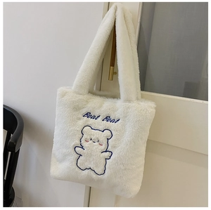 Vue détaillée du sac cabas en peluche blanche avec broderie ours bleu et texture douce