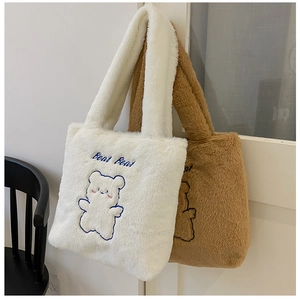 Gros plan de sacs cabas en peluche blanc et marron avec broderie ours sur une porte
