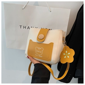 Detail of crossbody bucket bag with cartoon bear pattern and yellow shoulder strap
