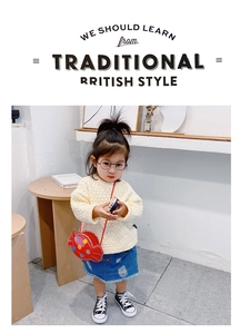 Détail d'un joli sac bandoulière rouge en forme de bonbon pour tenue de fille