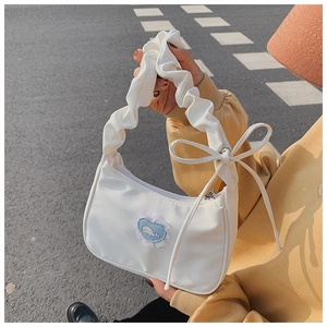 Nahaufnahme der weißen Schultertasche mit Falten, Bandschleife und Wal-Herz-Patch
