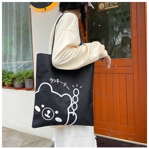 Detail view of large black canvas tote bag with white cartoon bear and Japanese text