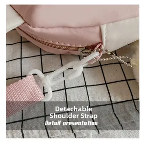 Detail of the detachable pink woven shoulder strap with white plastic hook for crossbody bag
