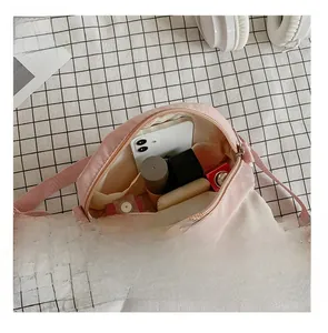 Pink rabbit ear crossbody bag showing interior storage capacity for phone and cosmetics