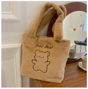 Détail du sac cabas en peluche kaki avec broderie ours sur fond en bois cosy