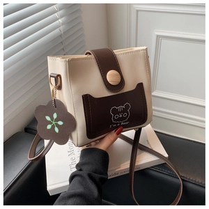 Detail of crossbody bucket bag with cartoon bear pattern and decorative flower pendant