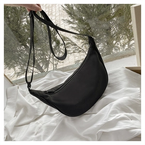 Detailed macro view of the black nylon crescent bag with adjustable strap and zipper closure