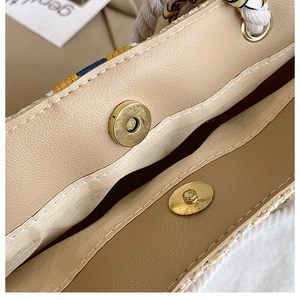 Macro shot of golden magnetic snap button and brown leather lining on a woven tote bag