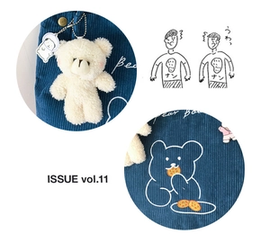 Close-up of blue corduroy tote bag texture with plush bear and cartoon pendants