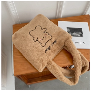 Détail du sac cabas en peluche kaki avec broderie d'ours et lettrage sur le devant