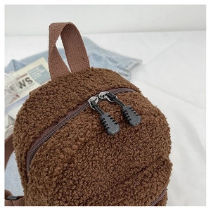Detail of fluffy brown sherpa mini backpack with sturdy dual zippers and webbing handle