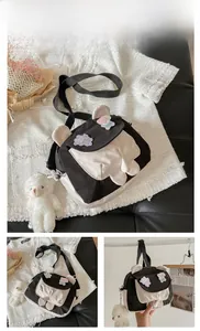 Detail of crossbody bag featuring cute bear ears, cartoon applique, and plush bear charm