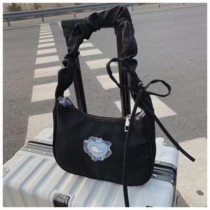 Detail der schwarzen Plissee-Schultertasche mit Herz-Spitzenstickerei und Seidenschleife