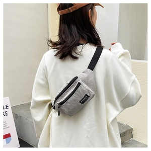 Rear view of a light gray corduroy chest bag featuring black straps and fashion label