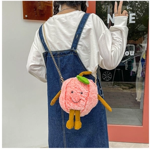 Detail of pink plush peach crossbody bag with metal chain strap and cute face
