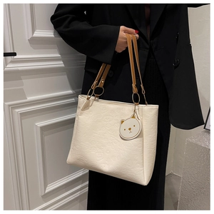 Detailed relief of cartoon embossed patterns on soft cream faux leather tote bag
