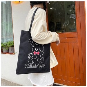 Detail of black canvas tote bag with cartoon rabbit print and HELLO TOY text