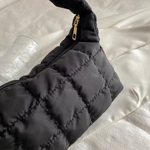 Chic black quilted puffer hobo bag with gold zipper and minimalist dumpling shape design