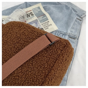 Detail shot of brown faux shearling backpack with adjustable woven shoulder strap