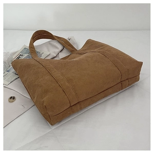 Detailaufnahme der braunen Cord-Tragetasche mit ästhetischem Styling auf weichem Untergrund