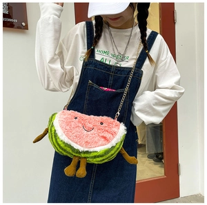 Close-up of watermelon-shaped plush bag with cartoon smile and gold chain strap