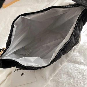 Quilted black shoulder bag with chic pleated design and white fabric inner lining