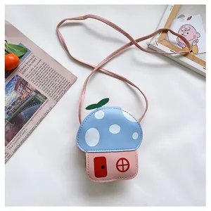 Détail d'un sac bandoulière enfant en forme de champignon avec toit bleu à pois blancs