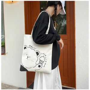 Detail of white canvas tote bag featuring cartoon bear print and ice cream motifs