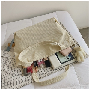 Detail of cream corduroy tote bag showing striped texture and large capacity for essentials