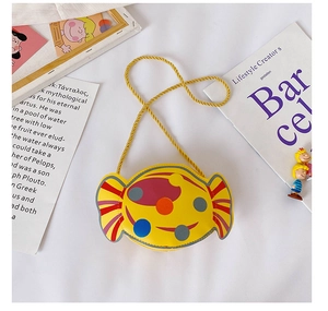 Détail du sac à bandoulière enfant jaune en forme de bonbon avec pois et sangle tissée
