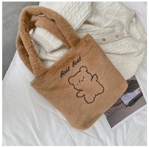 Détail d'un cabas en peluche marron avec broderie ours et poignées douces