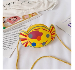Détail du sac à bandoulière en forme de bonbon avec pois et sangle dorée