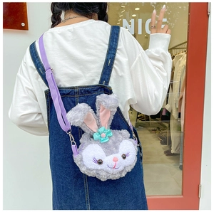 Detail view of the purple plush rabbit shoulder bag with adjustable strap worn by a person