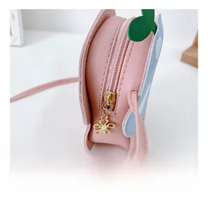 Gros plan du curseur de fermeture doré en fleur et détails de couture du sac rose