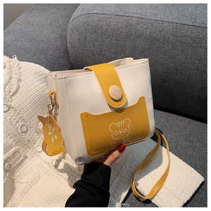 Detail of a white bucket bag with yellow trim and cute cartoon bear pattern
