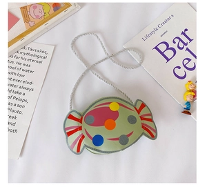 Détail du sac bandoulière en forme de bonbon avec pois colorés et bandoulière tressée