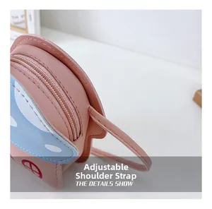 Détail montrant la bandoulière réglable du sac rose en forme de maison champignon