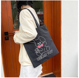 Detail of black canvas tote bag with white cartoon rabbit and HELLO TOY print design