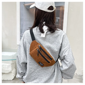 Detailed back view of a brown corduroy crossbody chest bag with adjustable black strap