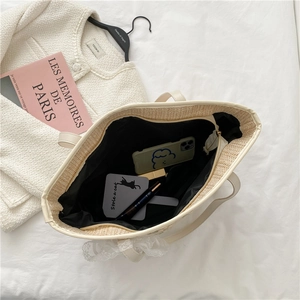 Chic beige straw tote bag with lace bow and black lining for summer outings