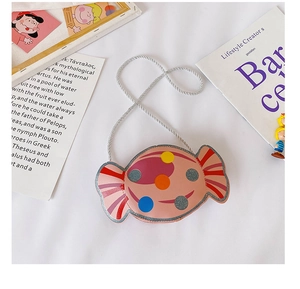 Vue détaillée du sac à bandoulière rose en forme de bonbon avec des pois colorés et sangle
