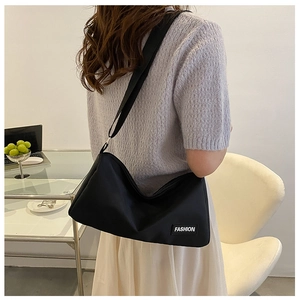 Détail du sac bandoulière noir en tissu Oxford avec sangle réglable et étiquette mode