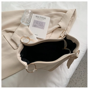 Macro shot of large beige tote bag with black fabric lining and golden ring hardware